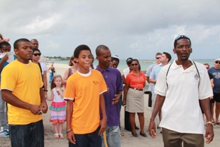 Young members of the Nevis Turtle Group (L-R) Mr. Jervanito Huggins, his brother Mr. Jaleel Huggins, and Mr. Stedroy Sturge who joined the Nevis Sea Turtle Group being lauded publicly by the Group’s President Mr. Lemuel Pemberton. Looking on are Guests and workers at the Four Seasons Resort, Nevis